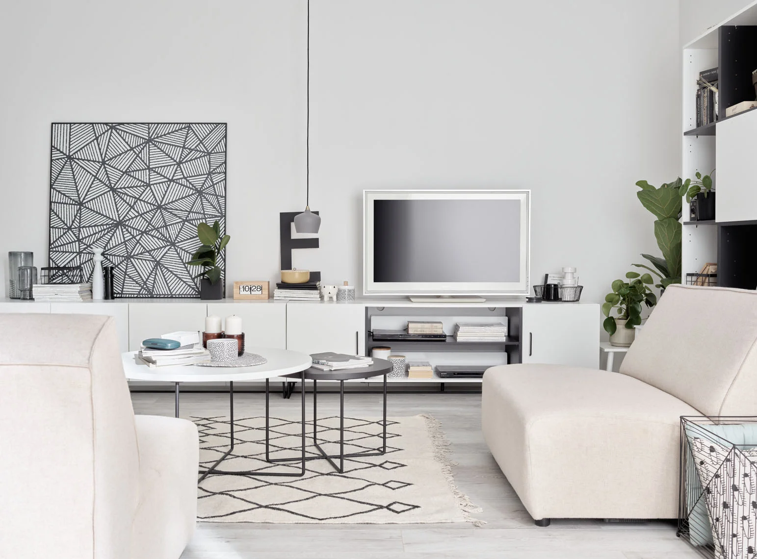 Salon w stylu minimalistycznym z białą sofą, geometrycznym dywanem i czarno-białymi dekoracjami